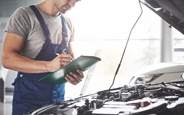 Car servicing 640x 400 Car mechanic looking under the bonnet of a car